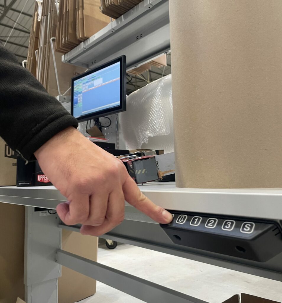 One hand presses a button on an adjustable preparation table.
